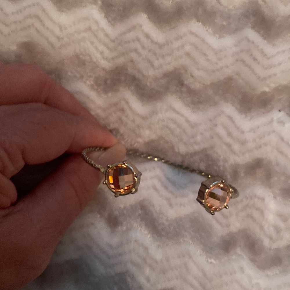 Goldtoned open bangle with pink crystals on edges